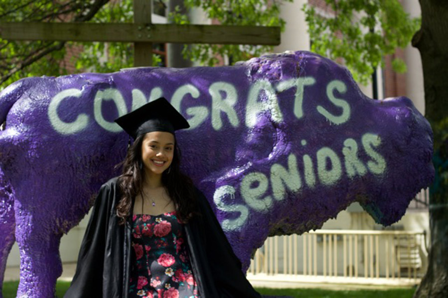 Pionero Scholar Angelica Wright posing in front of the Lipscomb Bison in her graduation robe
