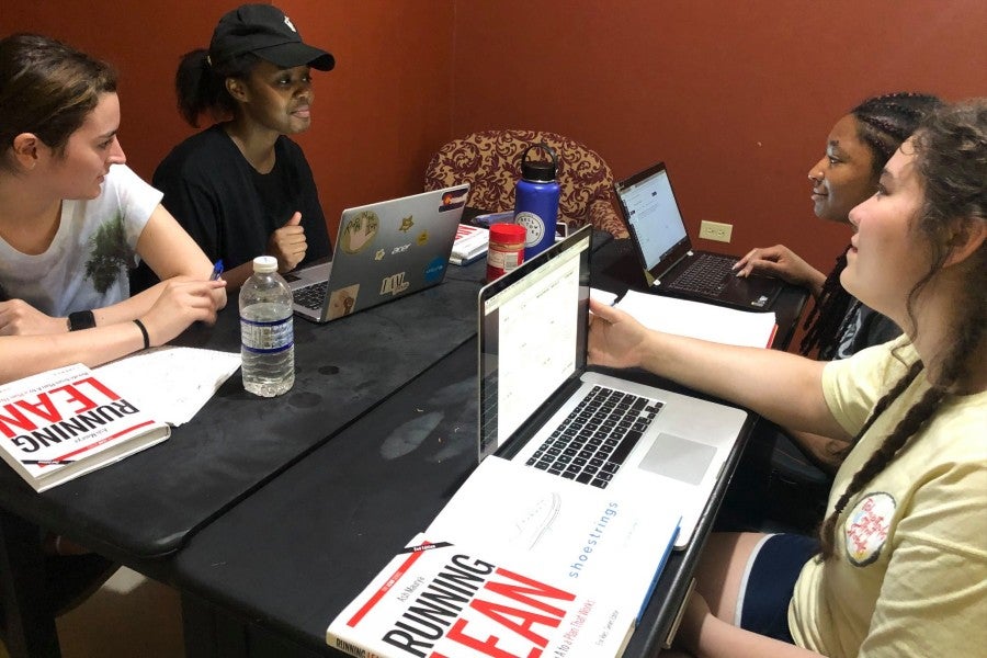 The three senior BAM Fellows and another fellow working at computer during Maymester in Jamaica.