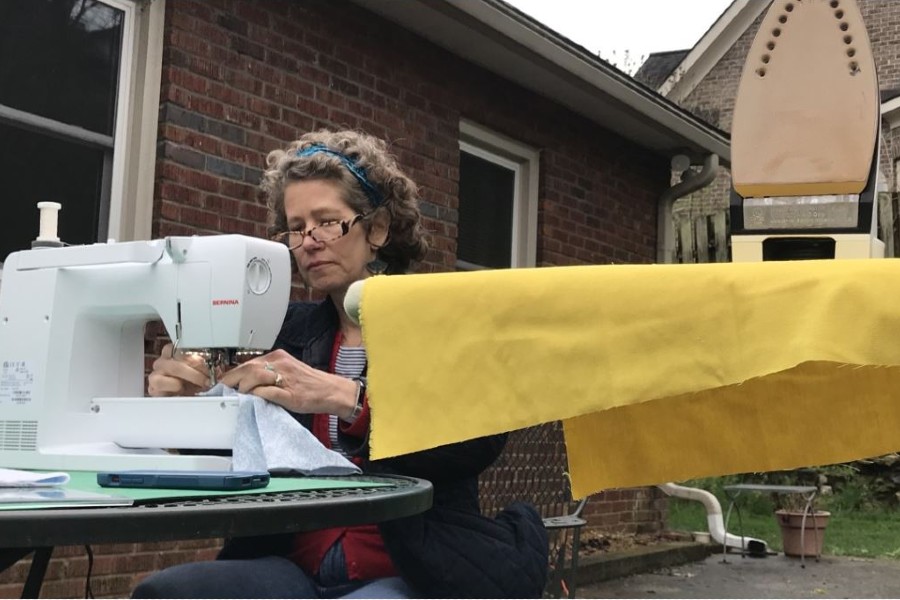 Channel 5 image of June Kingsbury sewing outside