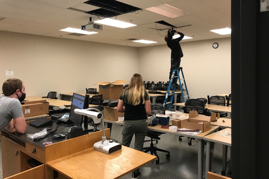 Employees installing new technology in classrooms
