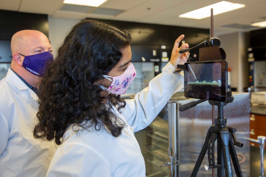 Student Pooja Patel helps Professor Brian Cavitt in the lab