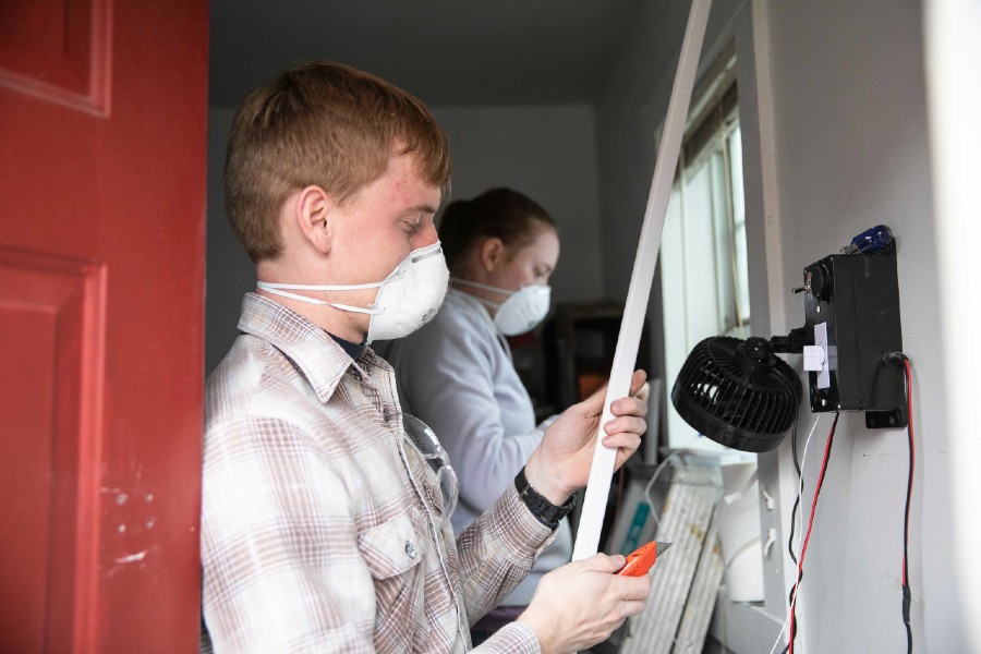 Students install a fan in one micro-home