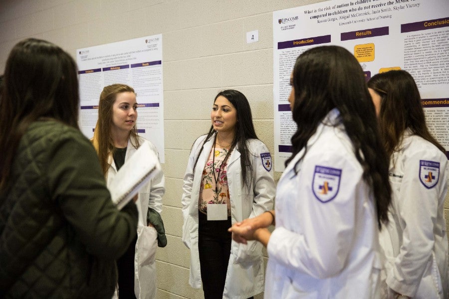 Students making poster presentations at symposium