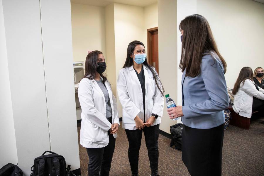 McQueen visits with two pharmacy students