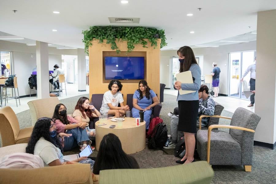 Dr. McQueen visits with students studying in the campus center