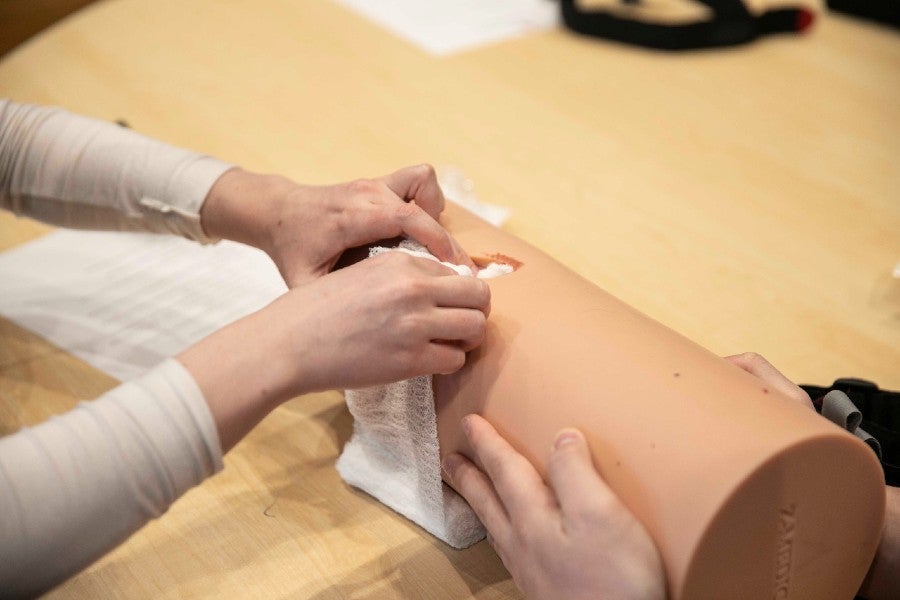 Students learn to stop a hemorrhage on a model limb