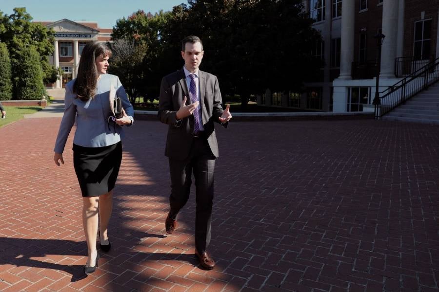 McQueen talks with Landon Parrish from the president's office.