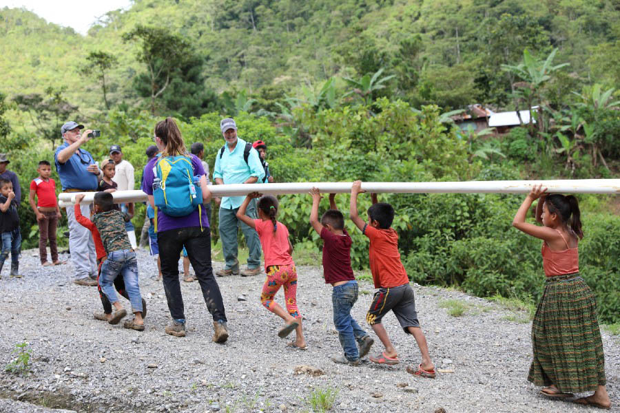 Children of the village helping haul pipe