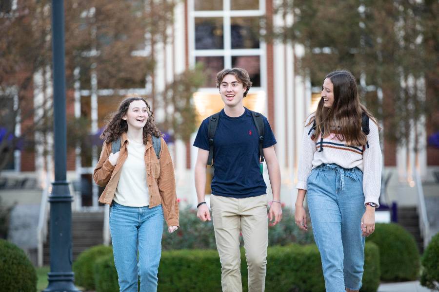 Three students walking on campus