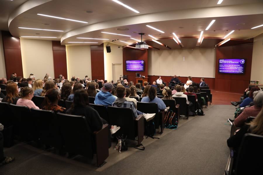 College of Business symposium session in a packed Stowe Hall. 