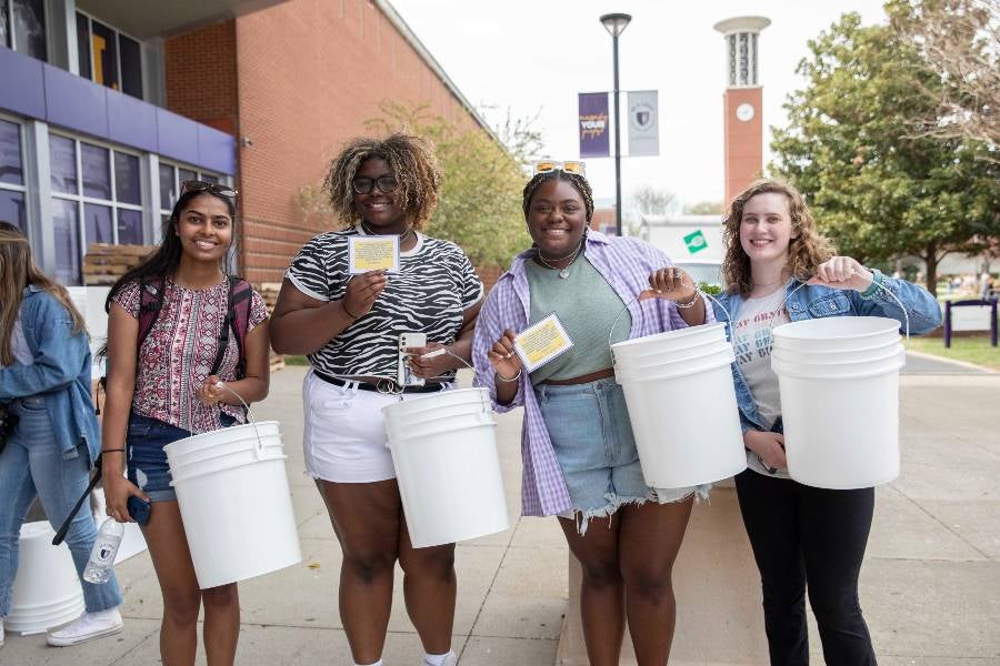 students filling buckets for Ukraine