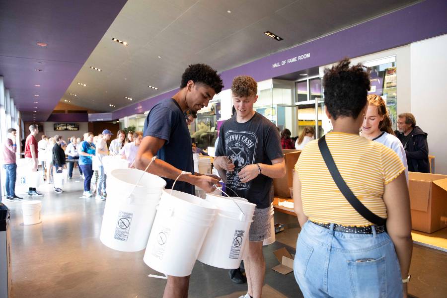 students filling buckets for Ukraine