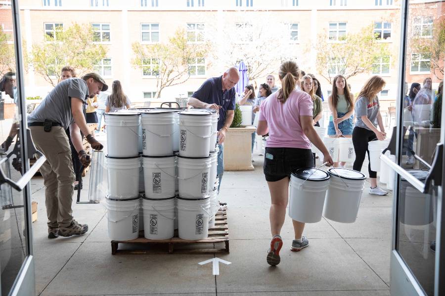 students filling buckets for Ukraine
