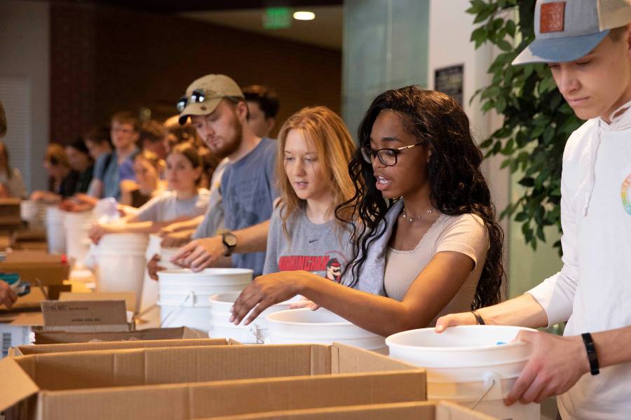 students filling buckets for Ukraine