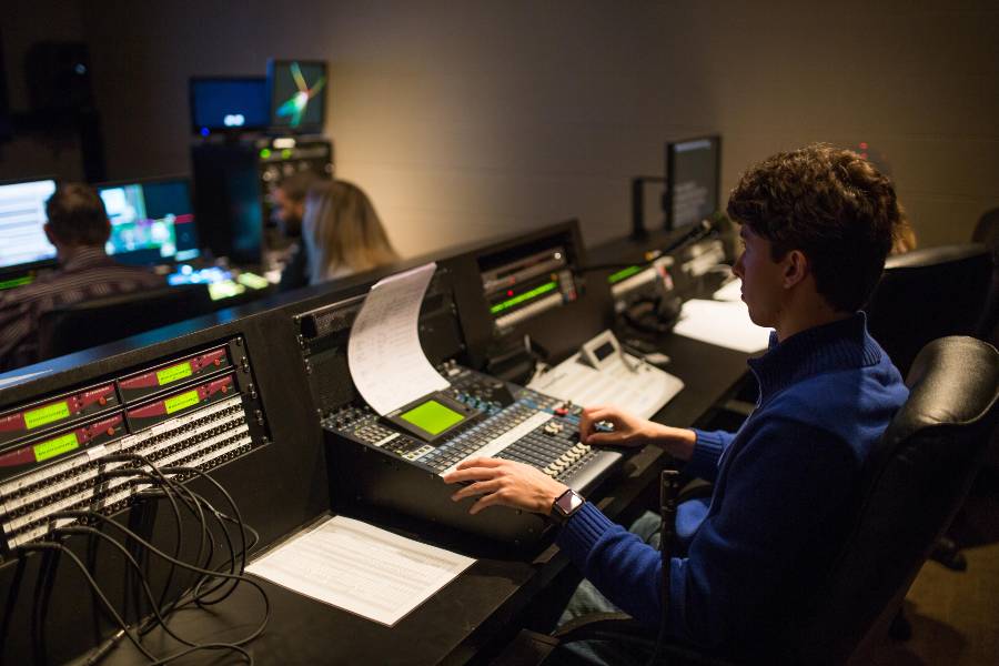 Student sitting at sound board