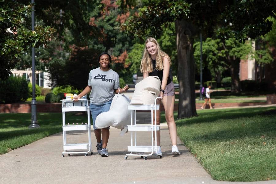 Two females moving into the dorms. 