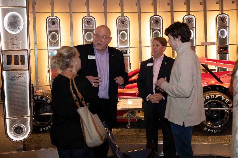 Group of faculty and alumni talking in Charlotte