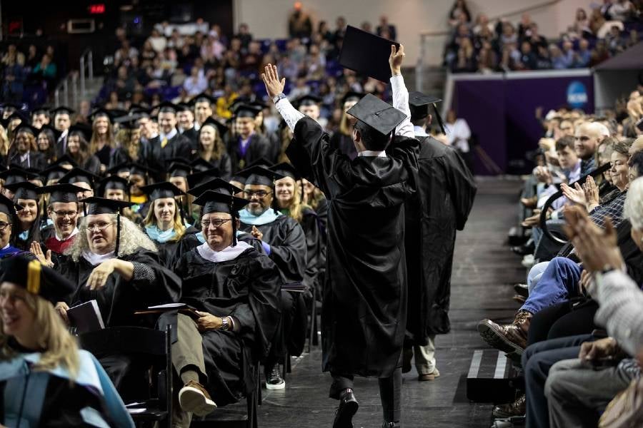 Daniel Youn raises his hands in the air after receiving his diploma.