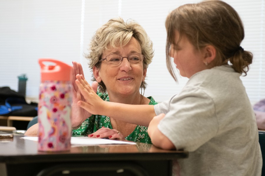 Dr. Catherine Stephens giving a student a high five