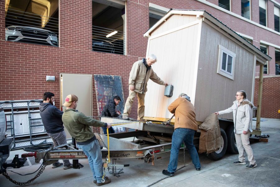 Students and the dean loading the microhome onto a trailer