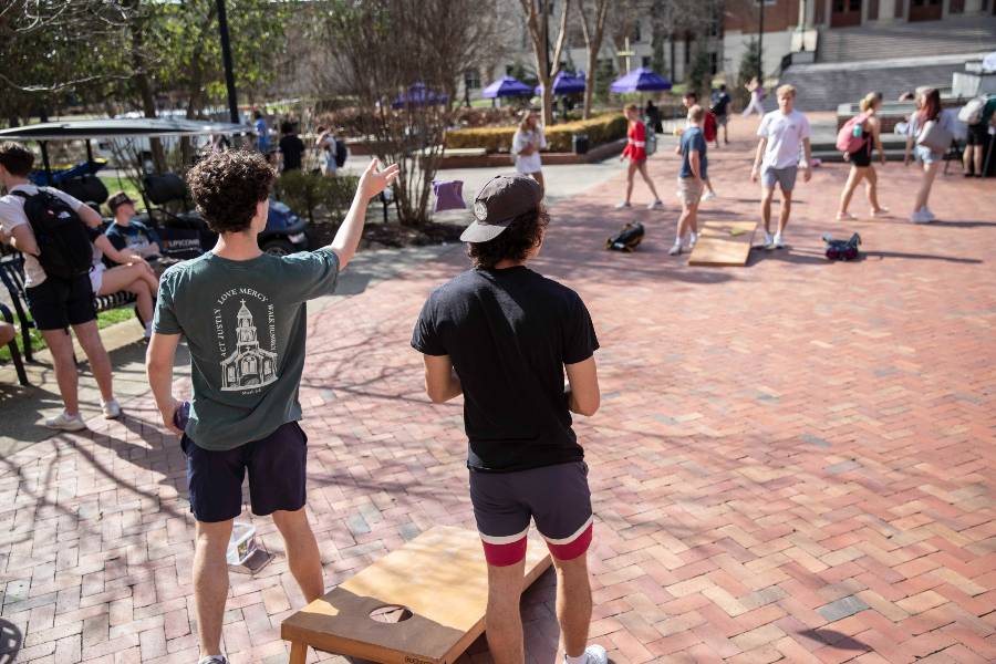 Students playing corn hole in Bison Square