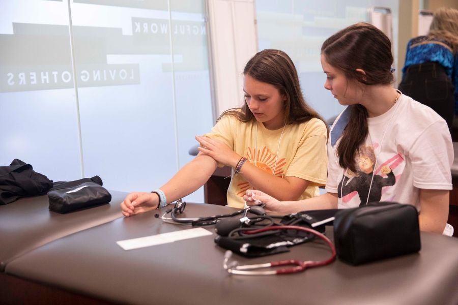 Students practice using blood pressure machine