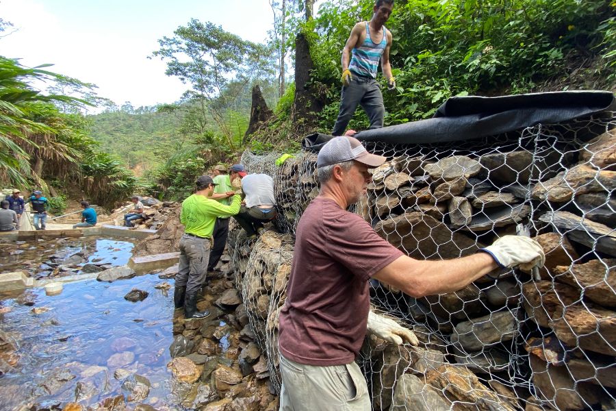 Garney and Lipscomb volunteers work at the source stream for the Maricha water distribution project