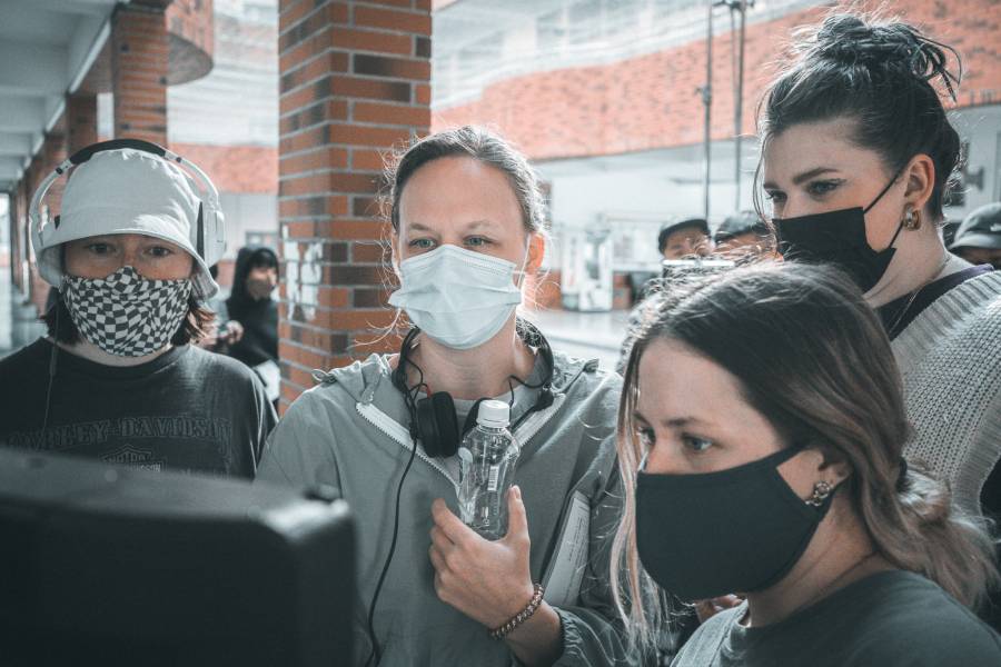 Sydney Tooley and her production team review a scene on set.