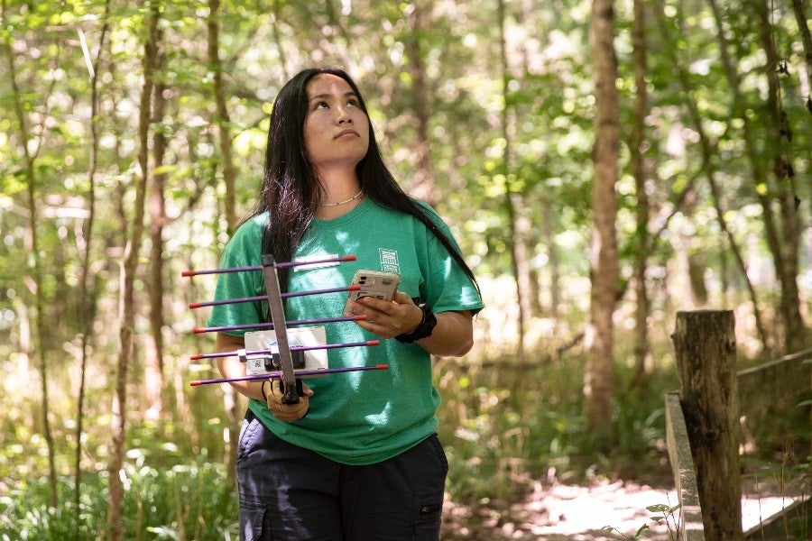 Anna Sawyer holds a cell phone and an antenna that shows the digital ID of nearby tags.