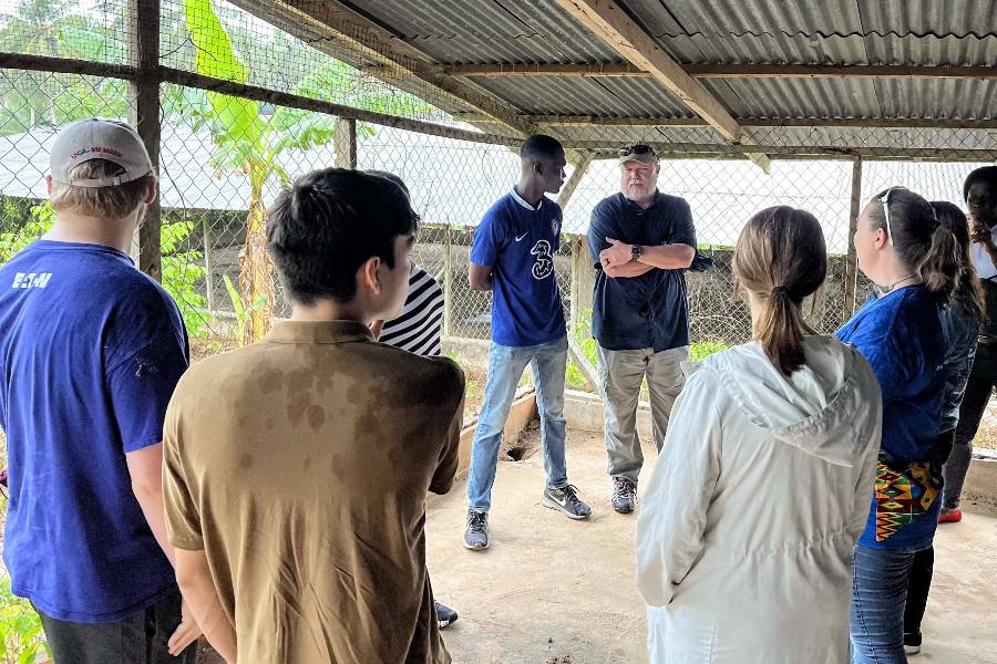 Business students and professor talking with locals in Ghana