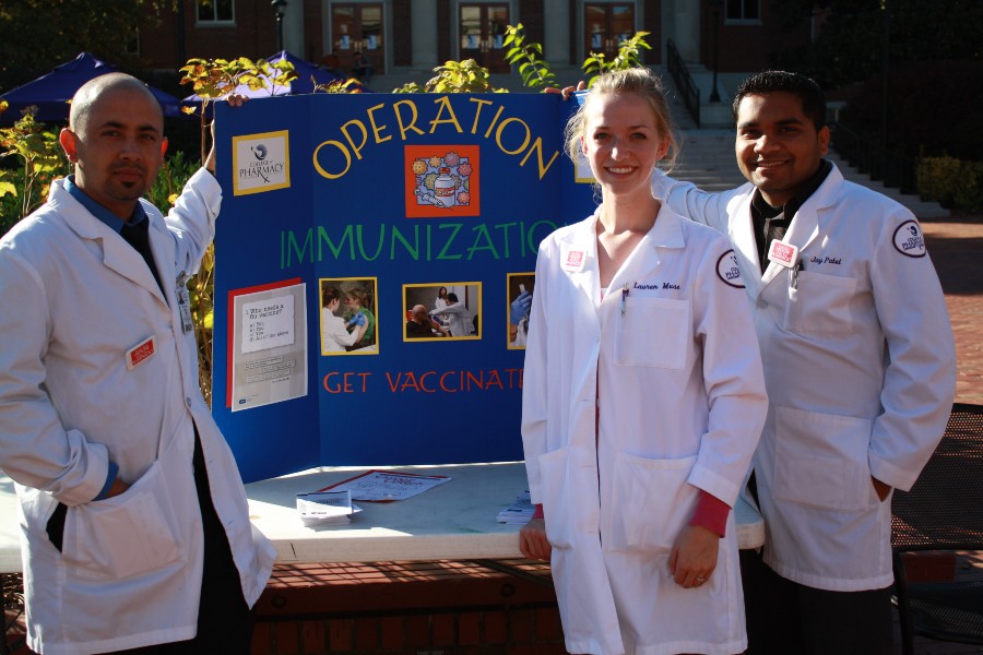 Pharmacy students with an Operation Immunization display