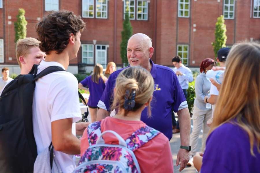 students circling around the professor at the grand opening