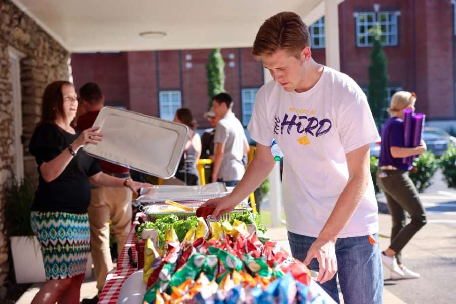 student grabbing snacks at the grand opening