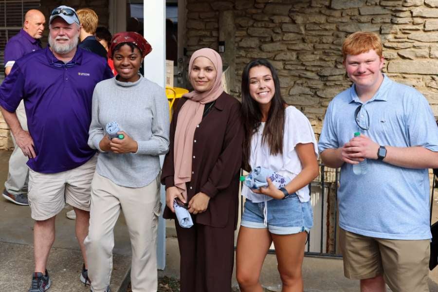 students and professor smiling