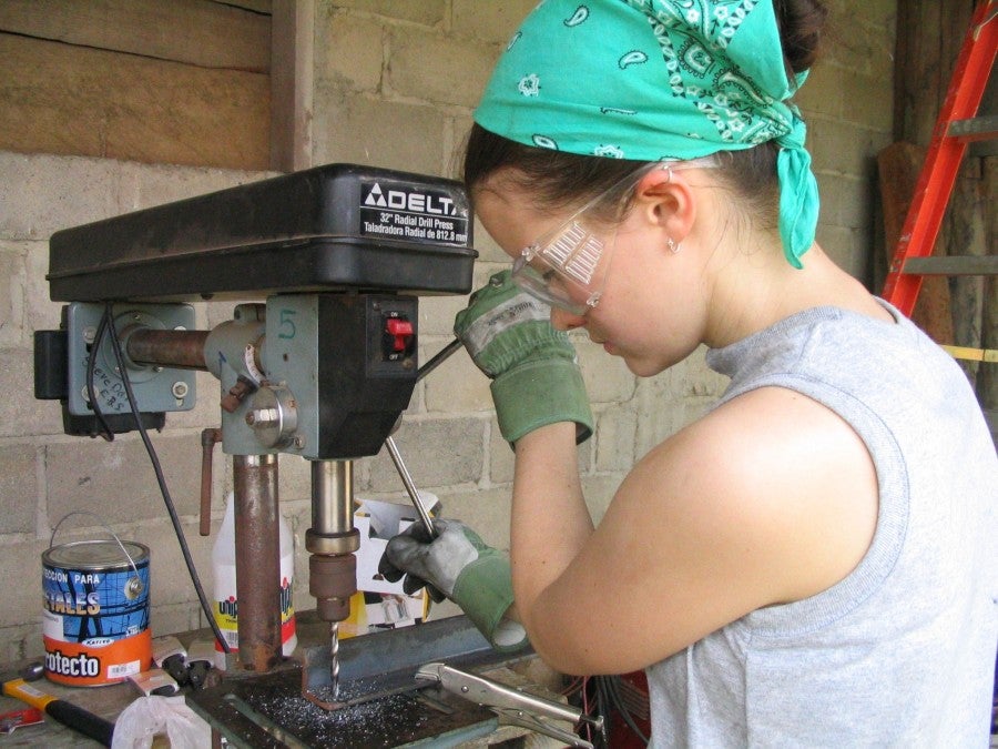 Amy Gilfilen Lucas working at a drill on the 2004 trip.