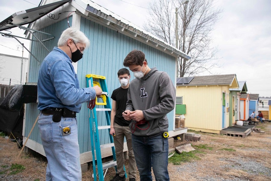 Engineering Dean David Elrod with students at microhome project