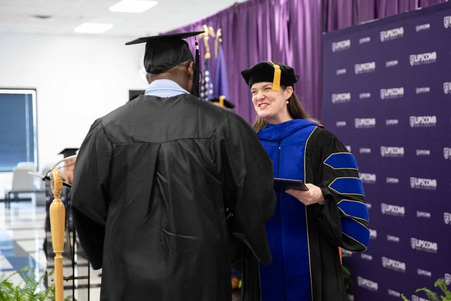 Dr. McQueen awards a diploma at the recent graduation ceremony.