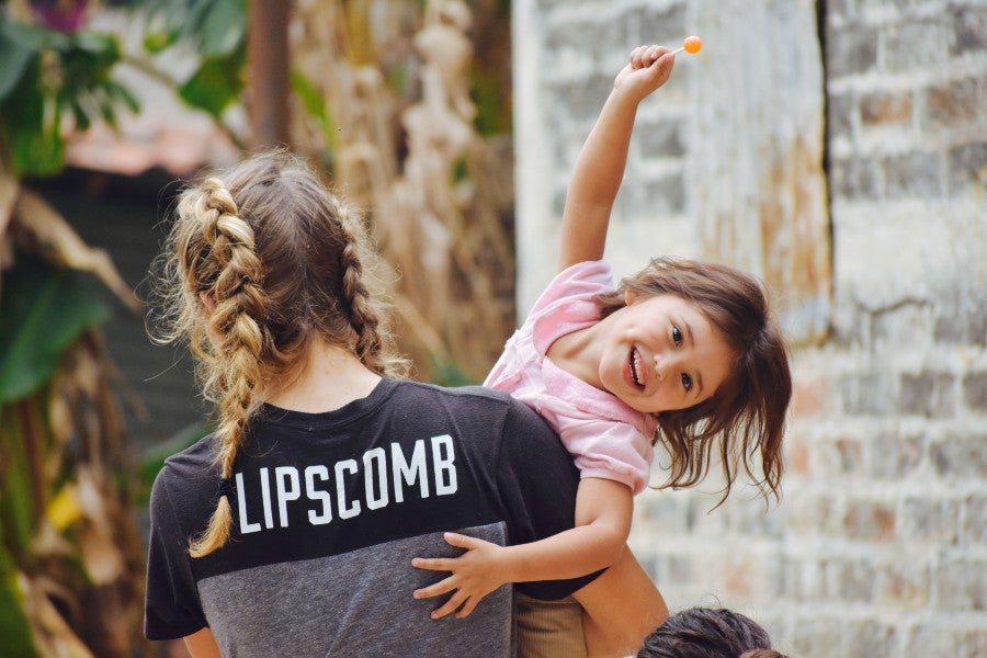 A Lipscomb student athlete with a young girl on a mission trip