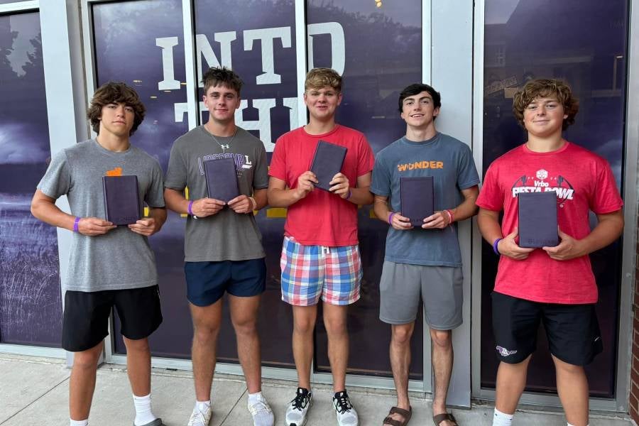 Students holding new Bibles in front of Allen Arena following family worship.