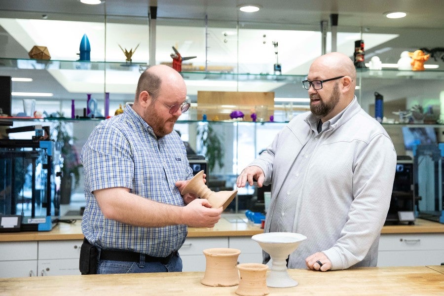 Sam Wright (left) and Terry Nichols (right) discussing the 3-D printed pottery samples.
