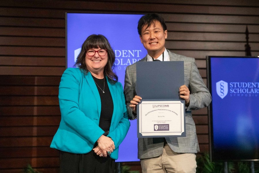 Kevin Wu receiving his symposium award from the provost