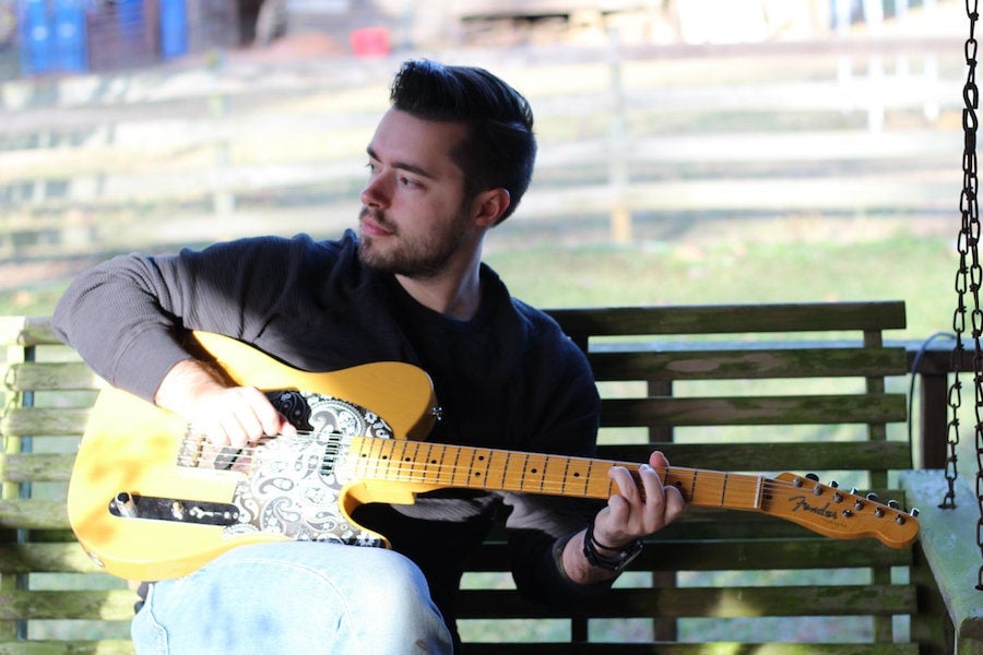 Patrick Carpenter holding a guitar