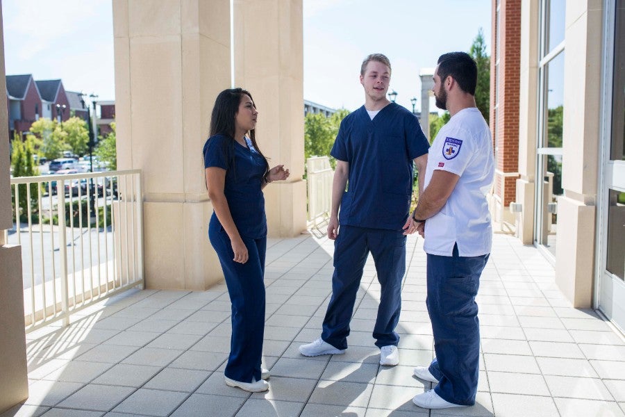 Two female and one male nursing students standing outside the Lipscomb nursing building. 