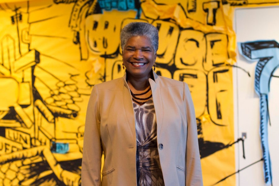 Norma Bond Burgess standing in front of yellow painting.