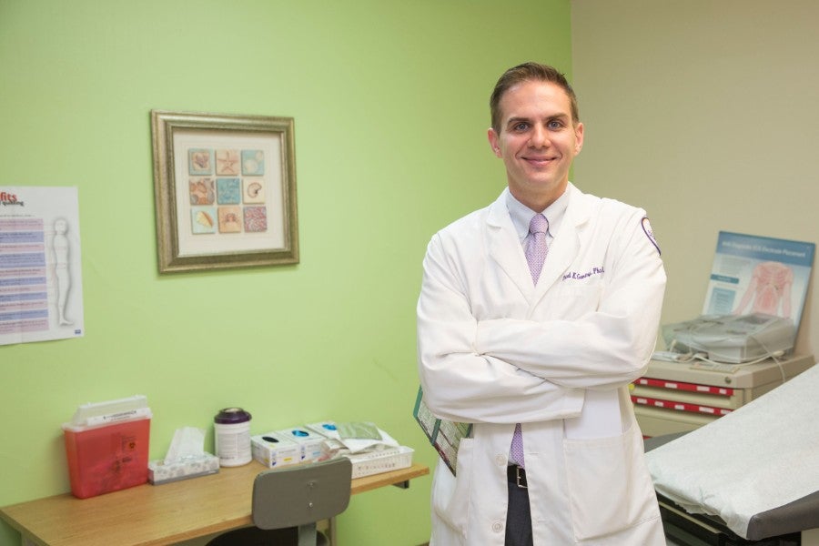 Chad Gentry in white lab coat in pharmacy