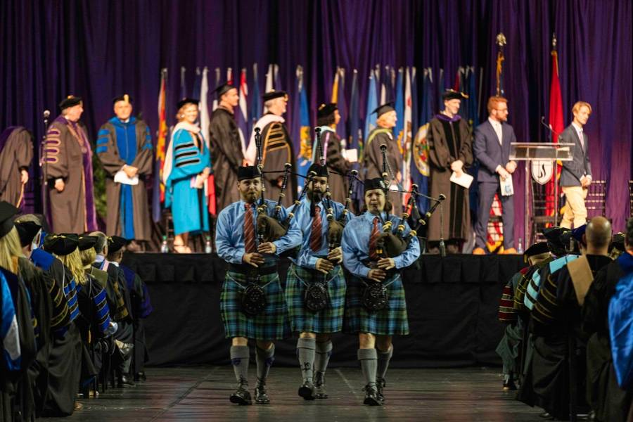 Three bag pipers marching at convocation