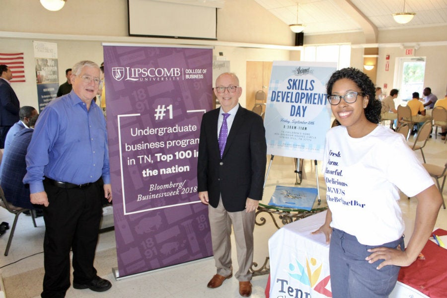 Three people standing in front of a banner