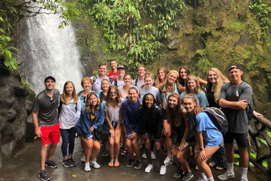 Group of students standing at waterfall