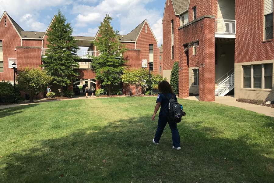 Student walking in front of dorms.