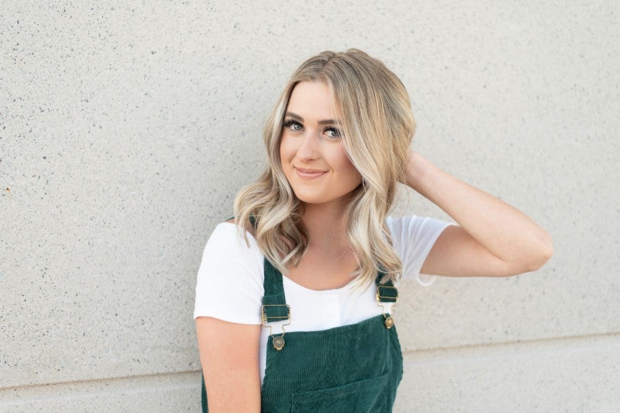 Photo of Ashlyn Grayce standing in front of wall.